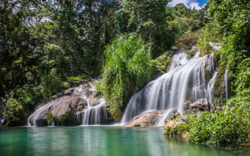 Wasserfall El Nicho in Kuba mit klarem Naturbecken, umgeben von tropischer Vegetation
