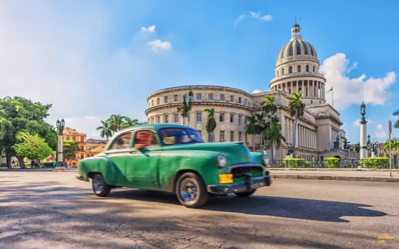 Grüner Oldtimer fährt am Kapitol in Havanna, Kuba – Symbol für Tagesausflüge durch die Hauptstadt mit kolonialer Architektur und kubanischem Flair.