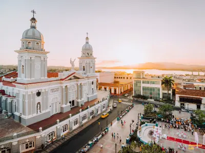 Blick auf die Kathedrale von Santiago de Cuba mit belebtem Platz im Abendlicht – historisches Zentrum der Stadt mit karibischem Flair.