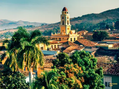 Blick über die Altstadt von Trinidad, Kuba mit kolonialen Dächern, Kirchturm und Palmen – UNESCO-Weltkulturerbe.